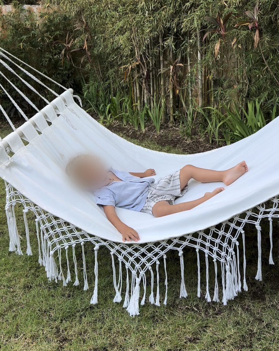 Juliëtte's zoontje ligt ontspannen in een hangmat in de tuin